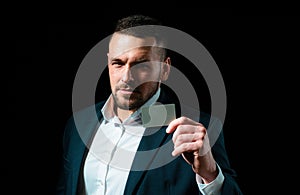 Businessman entrepreneur in suit holds credit card. Cashcard, creditcard, bank concept. Copy space for advertise photo