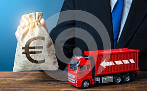 Businessman with Euro money bag and truck. High income of the transport business and the transport of goods.