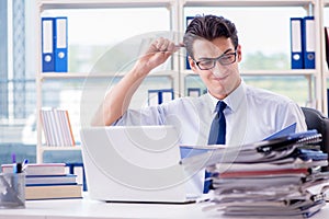 The businessman with excessive work paperwork working in office