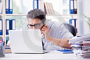 The businessman with excessive work paperwork working in office