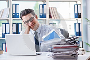 The businessman with excessive work paperwork working in office