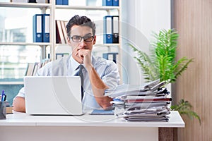 The businessman with excessive work paperwork working in office