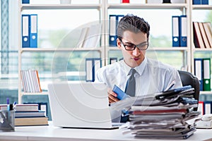 The businessman with excessive work paperwork working in office