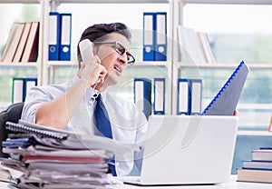 Businessman with excessive work paperwork working in office