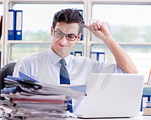 Businessman with excessive work paperwork working in office