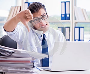 Businessman with excessive work paperwork working in office