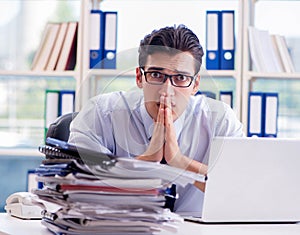 Businessman with excessive work paperwork working in office