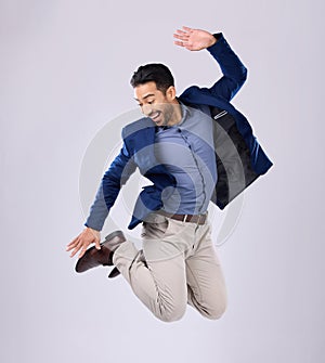 Businessman, excited and jumping in studio with happy smile with winning expression on white background. Freedom