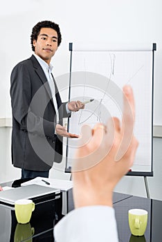 Businessman Explaining Graph With Colleague Raising Hand