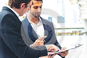 Businessman explaning the contract detail and waiting partner to sign the document outdoor