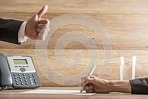 Businessman expressing his approval by making a thumbs up gestur