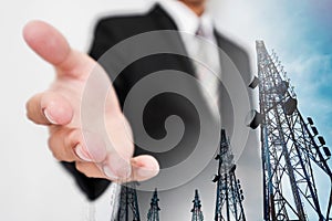 Businessman extending hand, with double exposure Telecommunication towers with TV antennas and satellite dish