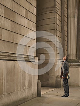 Businessman facing monumental building