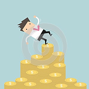 Businessman falling of money mountain