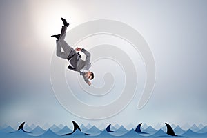 The businessman falling into sea with sharks