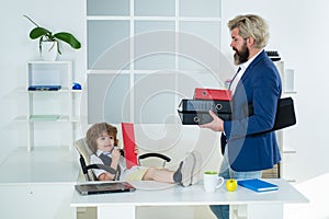 Businessman father with his son drawing on business papers at office. Boss and business man working together in office