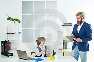 Businessman father with his son drawing on business papers at office. Team job.