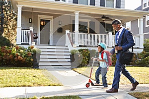 Businessman Father Walking Son On Scooter To School