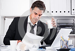 Businessman feeling thirsty in hot office