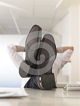 Businessman With Feet Up On Desk