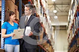 Businessman And Female Worker In Distribution Warehouse