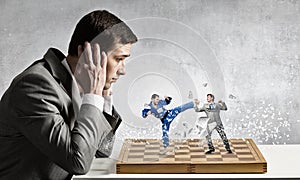 Businessman fighting on the chessboard