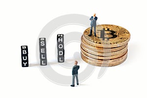 A businessman figurine standing on bitcoin stack while the other one looking at cubes