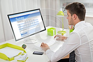 Businessman Filling Online Survey Form On Computer