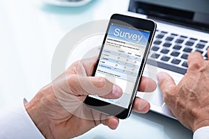 Businessman Filling Online Survey Form On Smartphone