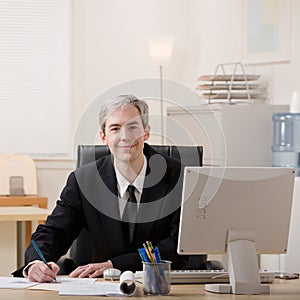 Businessman filling out paperwork at desk