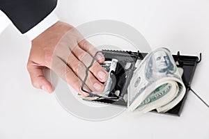 Businessman with finger in moustrap - business money trap concept.
