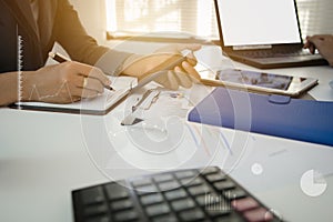 Businessman with finger touching screen of a digital phone at office on table with document graph data, Businessman calculate