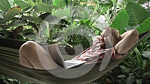 Businessman finishing work on laptop, relaxing on hammock