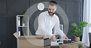Businessman finishing work and packing belongings in box