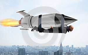 Businessman flies with a fast rocket. Concept of ambition and determination