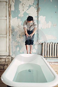 Businessman in flippers dives into the bathtub