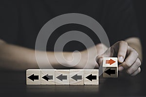 Businessman flipping and change direction of red arrow and black which print screen on wooden cube block , Technology and business