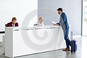 Businessman flirting at reception with female receptionist photo