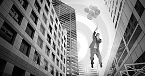 Businessman floating with balloons over surreal city buildings perspective