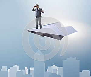 Businessman flying on paper plane in business concept