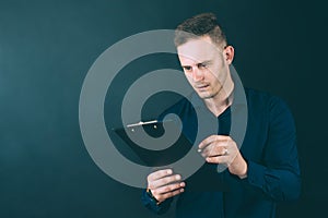 Businessman with a folder for documents in his hands, on a black background