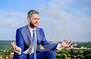 Businessman formal suit sit lotus pose and meditating outdoors. Entrepreneur find minute to relax and meditate. Man try