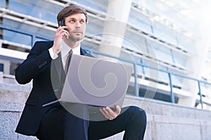 Businessman in formal suit use mobile phone and laptop