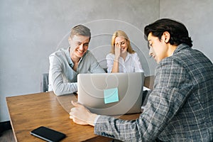 Businessman in formal wear giving presentation to colleagues at meeting in boardroom. Business people at conference room