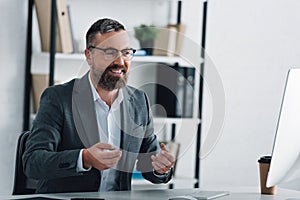 Businessman in formal wear talking in video chat in office