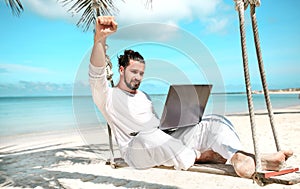 Businessman freelance on beach with laptop