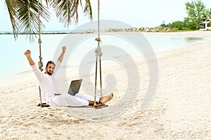 Businessman freelance on beach with laptop