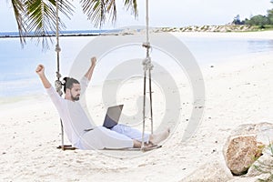 Businessman freelance on beach with laptop. Sand beach