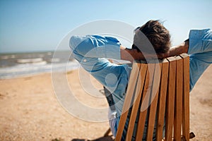 Businessman freelance on beach sitting with laptop.