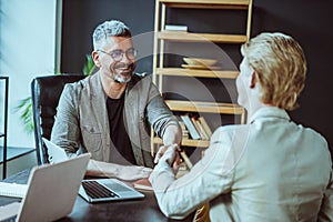 Businessman and Freelancer Shaking Hands at Desk